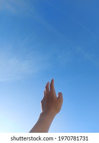 A Back Hand With Beautiful Clear Blue Sky In The Background Symbolizes A Person That Reaching A Dream As High As The Sky