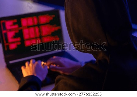 back hooded hacker  try to break through the security  with coding on the screen