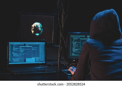 Back Hooded Hacker Using Malicious Software Hack Corporate Data Center. Malefactor Hidden Underground In Dark Place, Multiple Displays With Phishing Code And Global Map Attack.