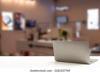 The Back Of The Laptop Is Blank, Placed On A White Desk, And Nobody, No People. Technology Work Concept, Smartphone, Notebook, Internet, Left Side Copy Space For Design, Close Up, Blurred Background.