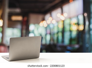 The Back Of The Laptop Is Blank, Placed On A White Desk, And Nobody, No People. Technology Work Concept, Smartphone, Notebook, Internet, Left Side Copy Space For Design, Close Up, Blurred Background.