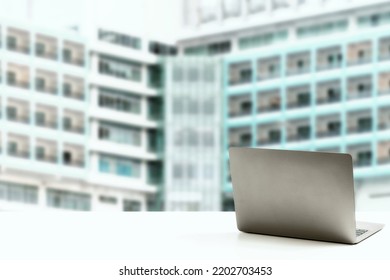 The Back Of The Laptop Is Blank, Placed On A White Desk, And Nobody, No People. Technology Work Concept, Smartphone, Notebook, Internet, Left Side Copy Space, Close Up, Blurred Background.