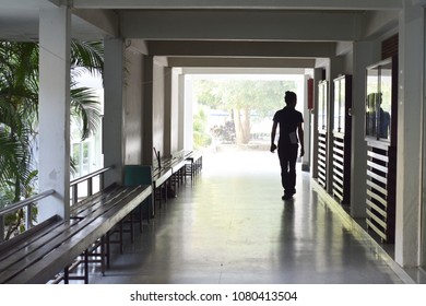 Back light of men walking through a framed walkway.