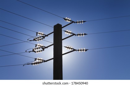 Back light silhouette of power line against blue sky. Alternatives energies