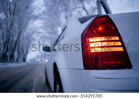 Back light of white car upside-down view. Winter landscape in bokeh