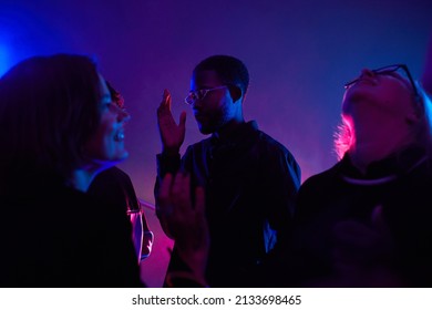 Back Lit Portrait Of Black Young Man Dancing In Crowd While Partying In Smoky Club Lit By Neon, Copy Space