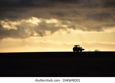 Back lit tractor in a stormy background