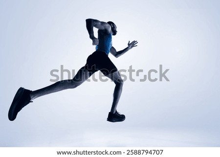 Back low angle view of man, professional runner in motion, training isolated on white studio background. Concept of sport, competition, endurance, athletics, sportive lifestyle. Copy space