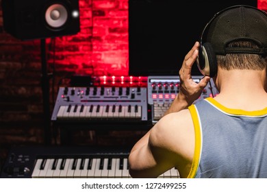 Back Of Male Asian Music Producer Arranging And Listening A Song In Home Recording Studio