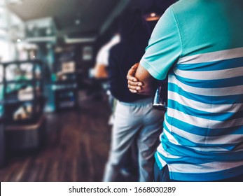 Back of man with stainless bottle standing in queue next to woman waiting for buy coffee. People Orderly in line with defocus