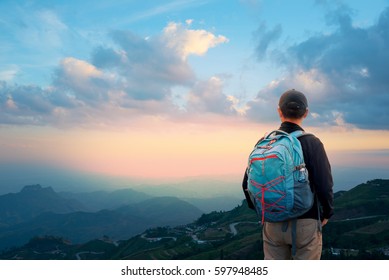 Zurück von Mann Backpacker im Mittelalter, der Bergausflug genießt.Asiatischer Reisender mit Rucksack auf der Spitze und Blick auf die Landschaft von Phu Tub Berk In Phetchabun, Thailand
