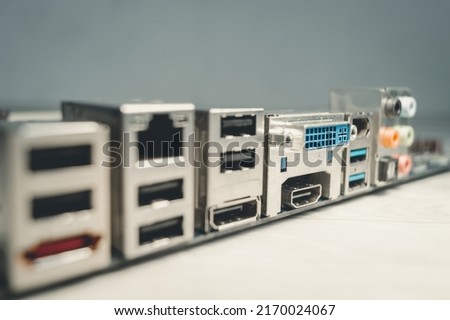 The back of a modern motherboard with a large set of ports for connecting peripheral equipment for a desktop computer. HDMI, USB, Ethernet, DVI, Audio ports. Selective focus