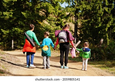 Back Of Mother With Three Kids Walking On Wood Mountains. Family Travel And Hiking With Childrens.