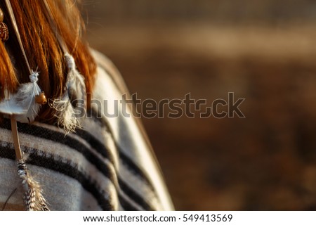 back of native indian american woman walking in mountains in evening, hair with feathers