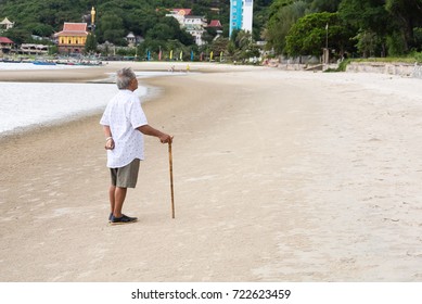 Back Of Old Man Standing With Staff On The Beach Sea And Looking Up.