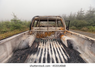 The Back Open Cab Of A Burnt Out Pick Up Truck Left Abandoned On Common Ground.