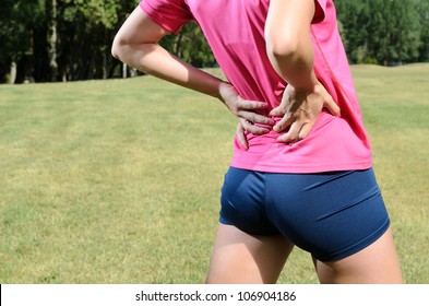 Back Pain Athlete. Sportswoman Backache And Injury. Female Young Runner With Sports Muscle Injury.