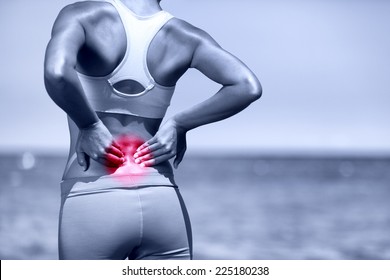 Back Pain. Athletic Running Woman With Back Injury In Sportswear Rubbing Touching Lower Back Muscles Standing On Road Outside.