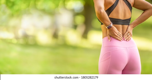 Back pain during sports. Young woman with an athletic figure and a lower back injury. - Powered by Shutterstock