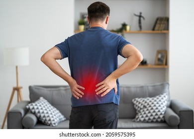 Back pain, kidney inflammation, man suffering from backache at home, painful area highlighted in red - Shutterstock ID 2059575395
