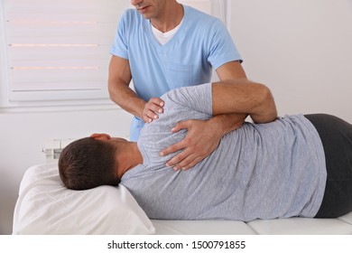 Back pain , Physiotherapy. Man Chiropractic pain relief adjustment /Kinesiology treatment . Osteopathy practitioner - Powered by Shutterstock