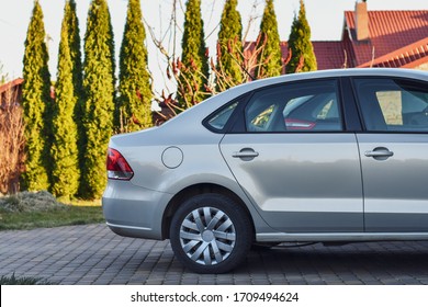 Back Part Of The Car Parked Near The Garage On The Background Of Garden.