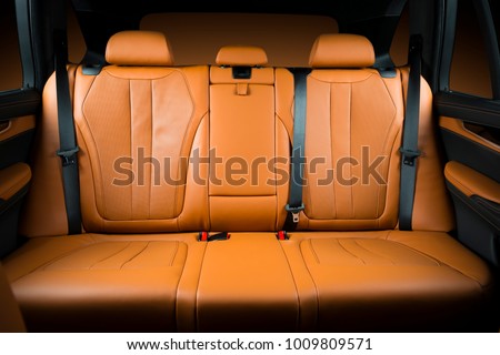 Back passenger seats in modern luxury car, frontal view, redo perforated leather with stitching