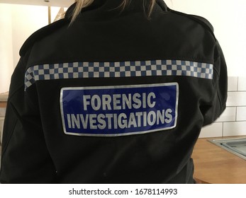 Back Of A Police Officer In Black Uniform With Writing Forensic Investigations 