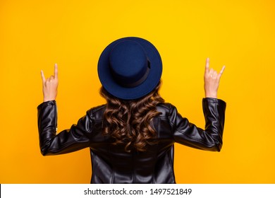 Back rear side photo of childish youth have weekends want party show horned symbol wear black leather jacket isolated over yellow color background