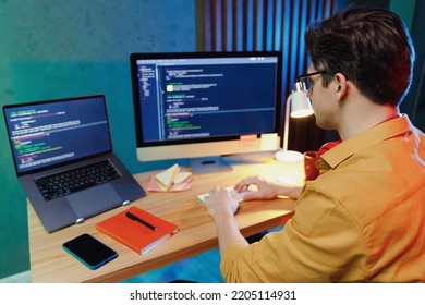 Back rear side view young smart data scientist software engineer IT specialist programmer man wearing shirt work at home writing programming code script on laptop pc computer. Game development concept - Powered by Shutterstock