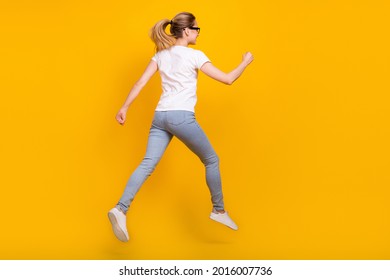 Back rear spine view photo of young woman jump up run empty space dream sale isolated on yellow color background