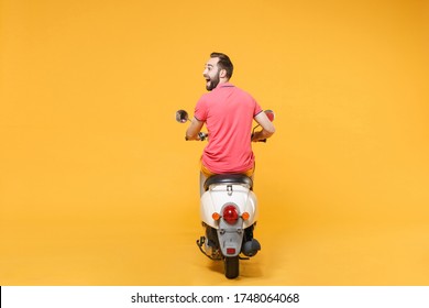 Back Rear View Of Excited Young Bearded Man Guy In Casual Summer Clothes Driving Moped Isolated On Yellow Wall Background. Driving Motorbike Transportation Concept. Mock Up Copy Space. Looking Aside