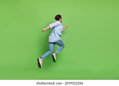 Back rear view full size photo of young guy hurry run jump wear casual outfit isolated over green color background - Powered by Shutterstock