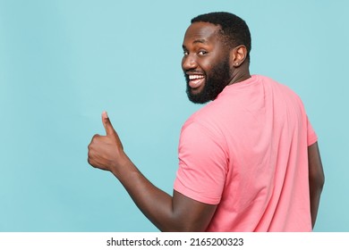 Back Rear View Funny Young Man Of African American Ethnicity 20s He Wears Casual Pink T-shirt Showing Thumb Up, Looking Camera Isolated On Pastel Plain Light Blue Color Wall Background Studio Portrait