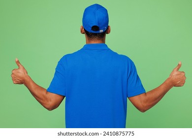 Back rear view professional delivery guy employee man wear blue cap t-shirt uniform workwear work as dealer courier showing thumb up like gesture isolated on plain green background. Service concept - Powered by Shutterstock