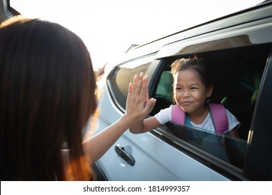 Back To School. Asian Pupil Girl With Backpack Sitting In The Car Waving Goodbye To Her Mother To Get Ready To School.