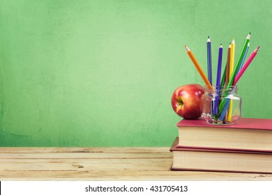 Back To School Background With Books, Color Pencils And Apple Over Green Wallpaper