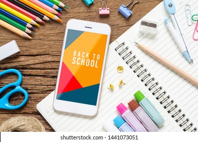 Back to school background concept. Mock up mobile phone for your artwork with School stationary items on rusty wooed background, top view flat lay background.