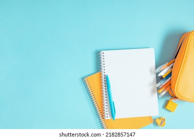 Back to school background. Flat lay, top view of colorful scattered stationery on isolated pastel blue table background. School supplies on desk. Copyspace. - Shutterstock ID 2182857147