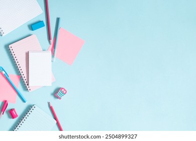 Back to school background. Flat lay, top view of school accessories, notebook, pens on isolated pastel blue table background. School stationery on desk. Copy space, banner 