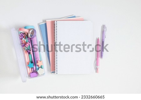 Back to school background. Flat lay, top view of school accessories, school pencil case with filling school stationery, notebook, pens on isolated white table background.  Stationery on desk. 