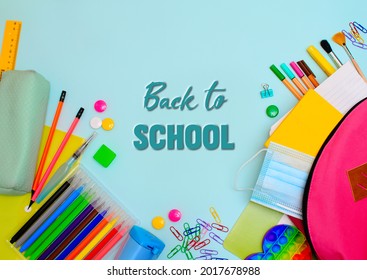 Back To School. Backpack For School Or College With Bright Colorful School Supplies On Light Blue Background. Stationery For School Children's Studies. Greeting Card. Flatlay