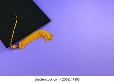 Back To School. Black Graduation Cap On A Purple Background. Graduation Concept. Black Mortar Board Cap.