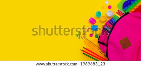 Back to school. Bright colorful school supplies and backpack for school or college on yellow background. Stationery for school children's studies. Greeting card or banner for sale. Copyspace. top view