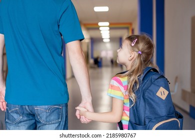 Back To School. Child With Father Holding Hands In School Hallway. Happy Kid Going To First Grade. Little Girl With Backpack Indoors. Concept Of Confidence, Support, Togetherness. First Day At