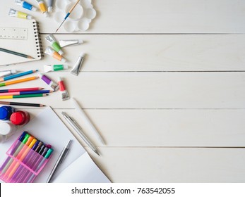 Back To School Concept And Artist Kid Concept With Drawing Book, Crayons, Coloured Pencils, Poster Color And School Stationery On White Wooden Background With Copy Space