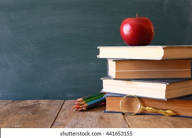 Back To School Concept. Blackboard With Books And Apple On Wooden Desk