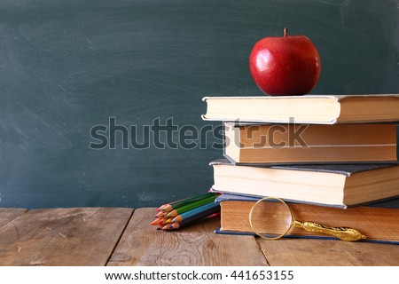 Back to school concept. Blackboard with books and apple on wooden desk
