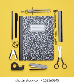 Back To School Concept, With A Closed Theme Book Surrounded By Classroom Supplies.