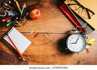 Back to school concept. School desk flat lay with stationery and alarm clock, copy space background banner